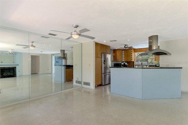 kitchen featuring island exhaust hood, stainless steel fridge with ice dispenser, and sink