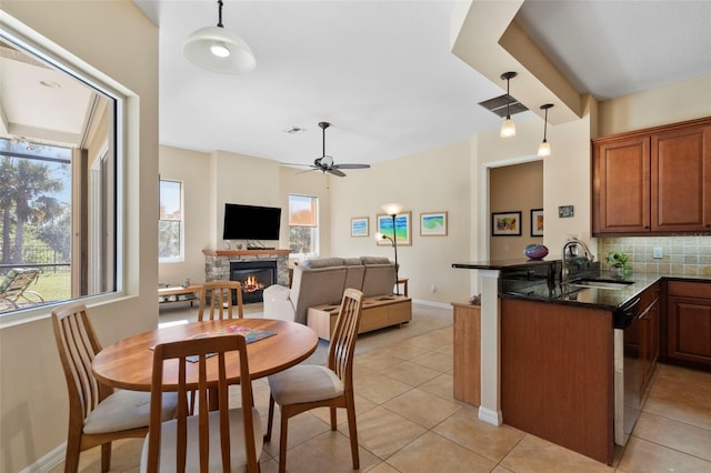 kitchen featuring kitchen peninsula, decorative light fixtures, a fireplace, and sink