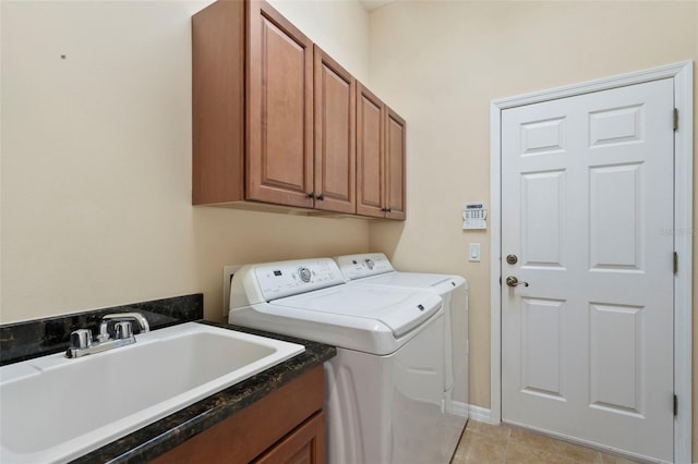 laundry room featuring cabinets, light tile patterned flooring, washer and clothes dryer, and sink