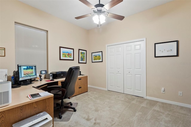 carpeted home office featuring ceiling fan