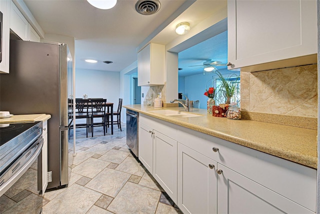 kitchen with dishwasher, backsplash, white cabinets, and sink