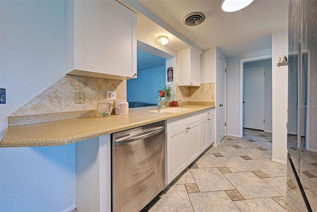 kitchen featuring backsplash, dishwasher, white cabinetry, and sink