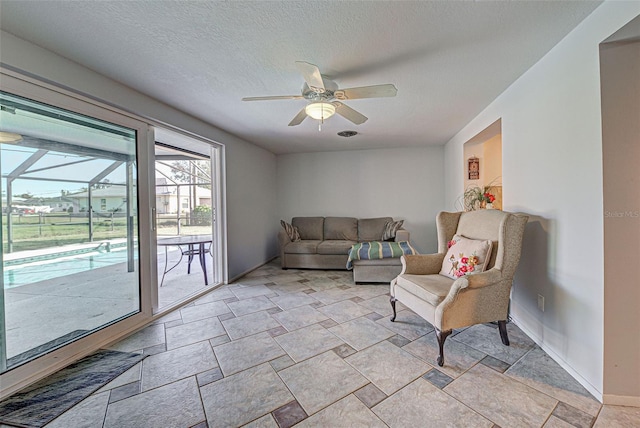 living area featuring a textured ceiling and ceiling fan