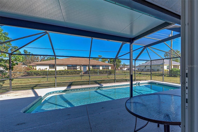 view of swimming pool with glass enclosure and a yard