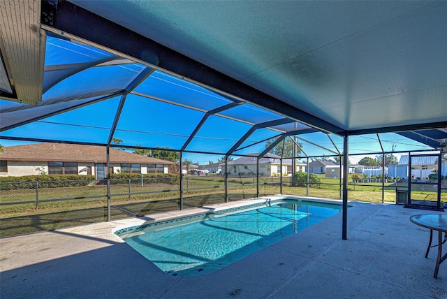 view of pool featuring a yard, glass enclosure, and a patio area