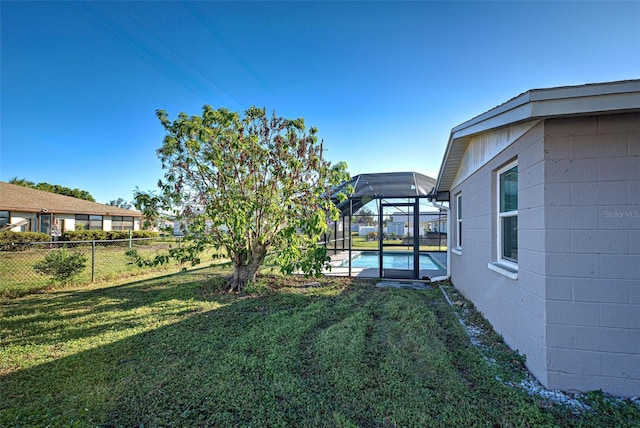 view of yard with glass enclosure and a fenced in pool