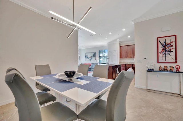 dining area with crown molding, sink, and light tile patterned floors