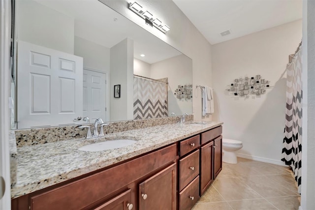 bathroom with toilet, vanity, and tile patterned floors