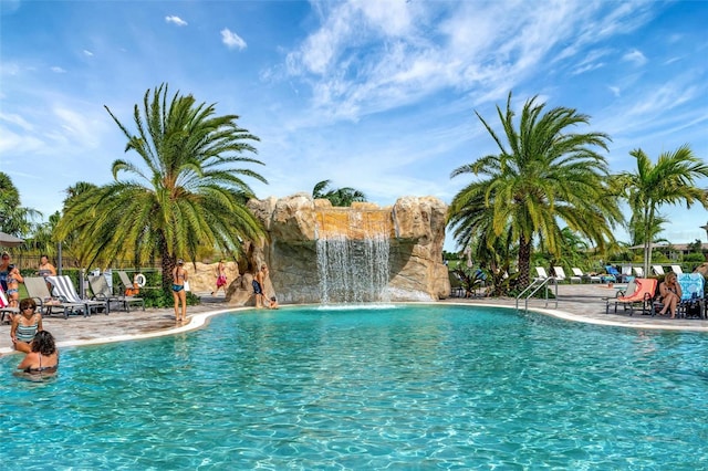 view of swimming pool with pool water feature and a patio