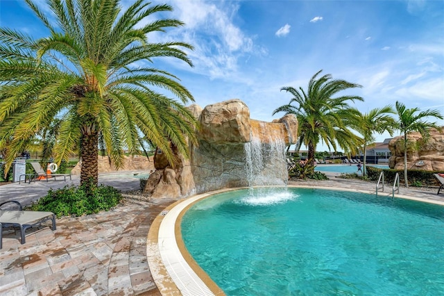 view of swimming pool with pool water feature