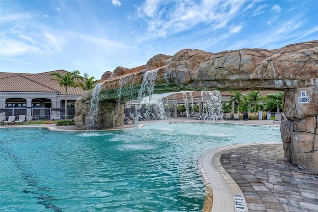 view of swimming pool with pool water feature