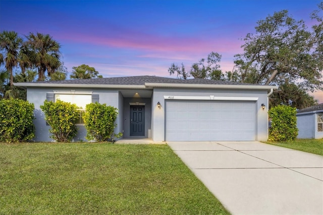 view of front of home with a yard and a garage