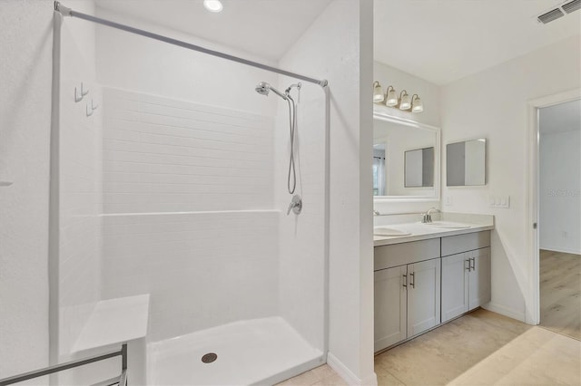 bathroom with walk in shower and vanity