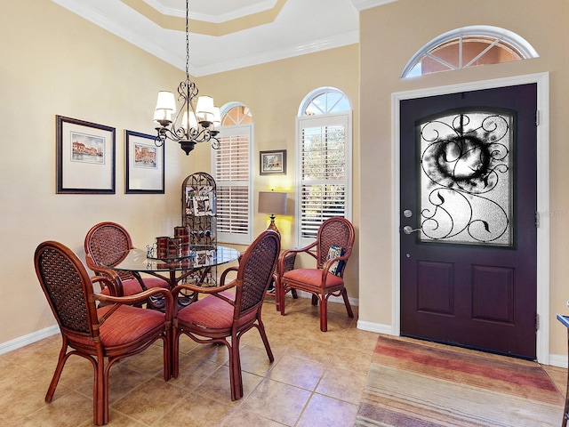 tiled dining space featuring a raised ceiling, ornamental molding, and an inviting chandelier