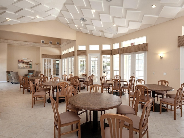 dining area with light tile patterned floors and a high ceiling