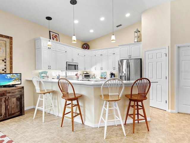 kitchen with a breakfast bar, white cabinetry, kitchen peninsula, and appliances with stainless steel finishes