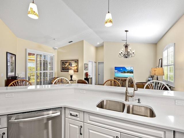 kitchen featuring lofted ceiling, sink, white cabinetry, hanging light fixtures, and dishwasher