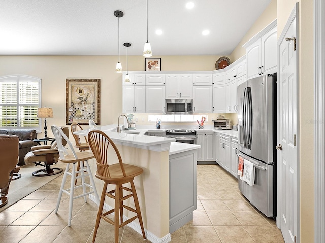 kitchen featuring white cabinetry, appliances with stainless steel finishes, pendant lighting, and light tile patterned floors