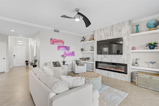 tiled living room featuring built in shelves, a large fireplace, ceiling fan, and ornamental molding