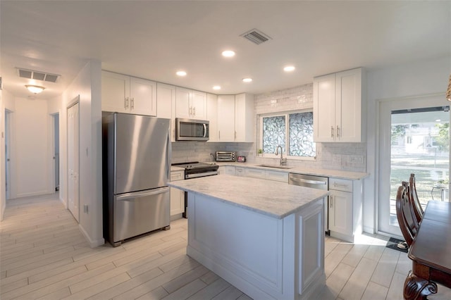 kitchen featuring white cabinetry, sink, a kitchen island, and stainless steel appliances