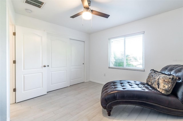 sitting room with light wood-type flooring and ceiling fan