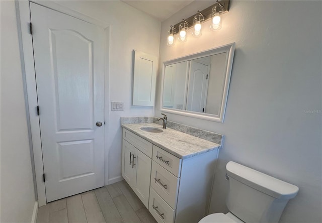 bathroom featuring hardwood / wood-style floors, vanity, and toilet