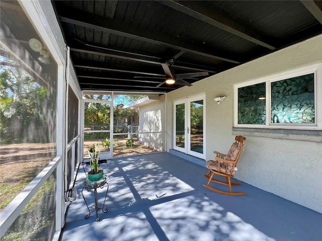 unfurnished sunroom with beam ceiling