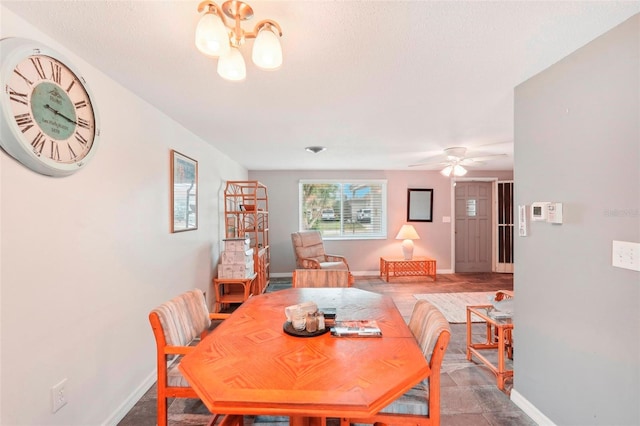 dining space with ceiling fan with notable chandelier