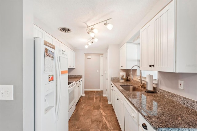 kitchen featuring white cabinetry, sink, dark stone countertops, a textured ceiling, and white appliances