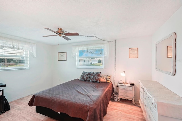 bedroom featuring a textured ceiling, light hardwood / wood-style flooring, and ceiling fan