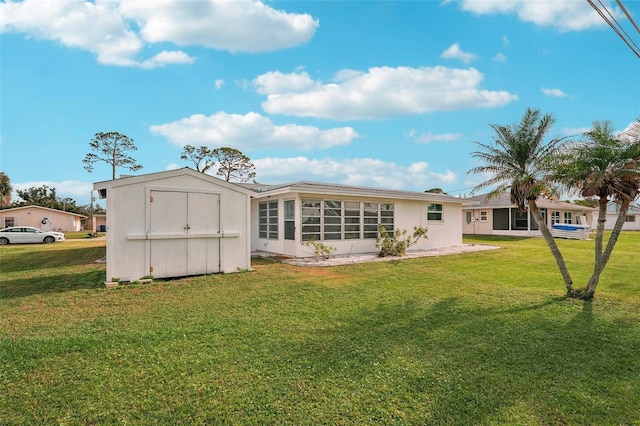 rear view of house with a yard and a shed