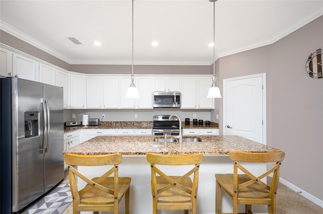 kitchen with white cabinets, sink, ornamental molding, appliances with stainless steel finishes, and decorative light fixtures