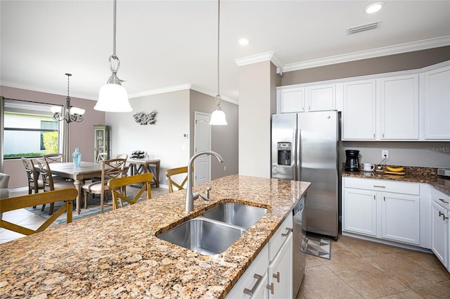 kitchen featuring sink, hanging light fixtures, light stone counters, white cabinets, and appliances with stainless steel finishes