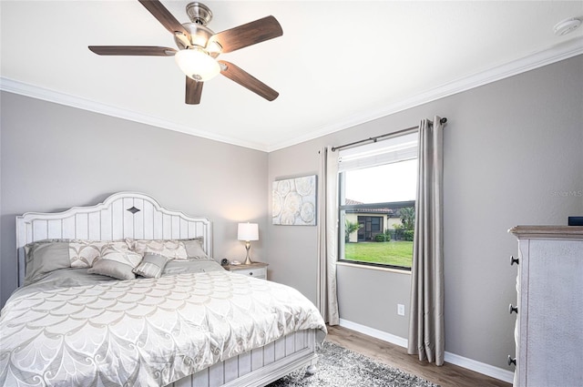 bedroom featuring hardwood / wood-style floors, ceiling fan, and ornamental molding