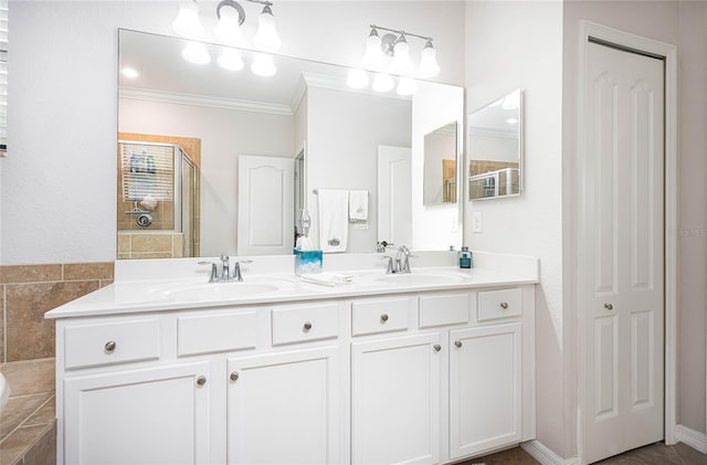 bathroom with vanity, an enclosed shower, and ornamental molding