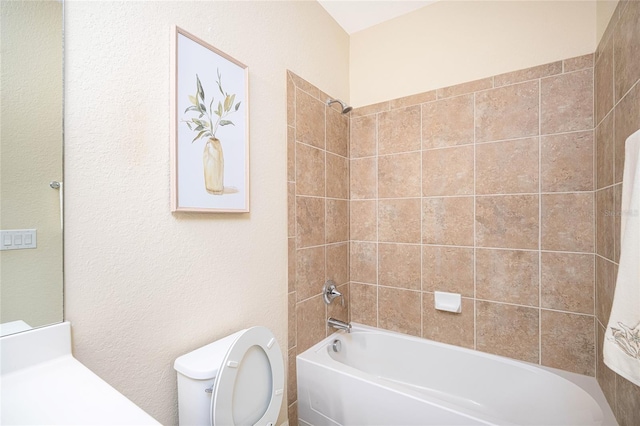 bathroom with tiled shower / bath combo and toilet