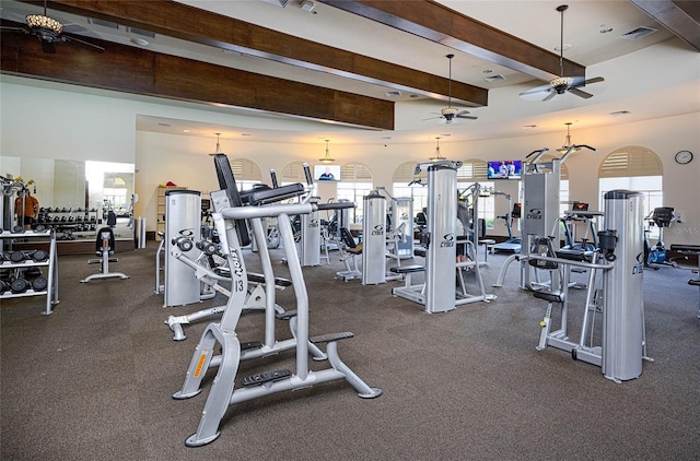 exercise room featuring ceiling fan and a high ceiling