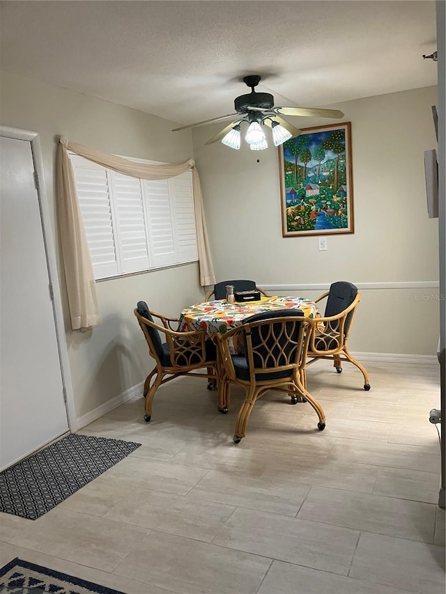 dining room featuring ceiling fan and a textured ceiling