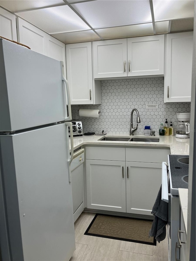 kitchen with white cabinets, white appliances, backsplash, and sink