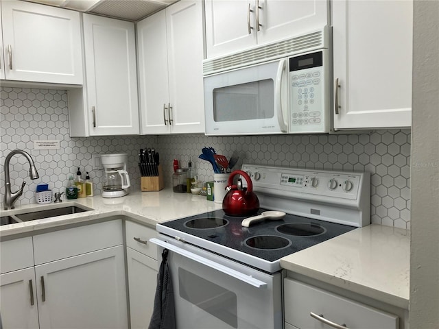 kitchen with decorative backsplash, white appliances, white cabinetry, and sink