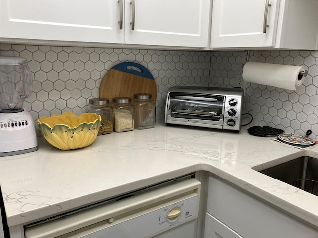 details featuring decorative backsplash, white cabinetry, dishwasher, and light stone counters