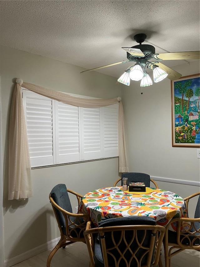 dining area featuring a textured ceiling and ceiling fan