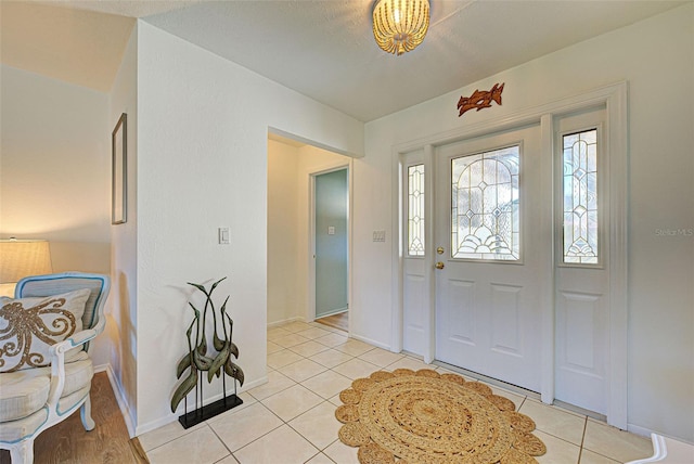 foyer featuring light tile patterned flooring and a textured ceiling