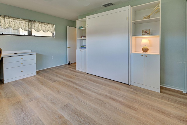 unfurnished bedroom with a closet and light hardwood / wood-style floors