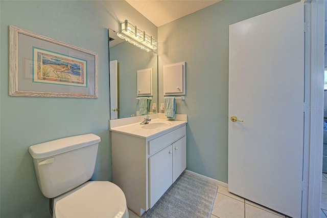 bathroom featuring tile patterned flooring, a textured ceiling, vanity, and toilet