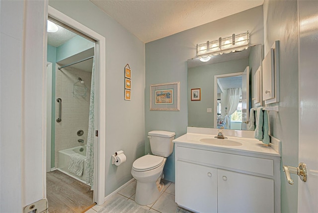 full bathroom featuring toilet, vanity, a textured ceiling, and tiled shower / bath combo