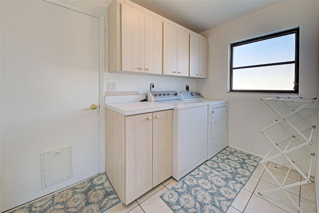 washroom with cabinets, light tile patterned floors, and separate washer and dryer