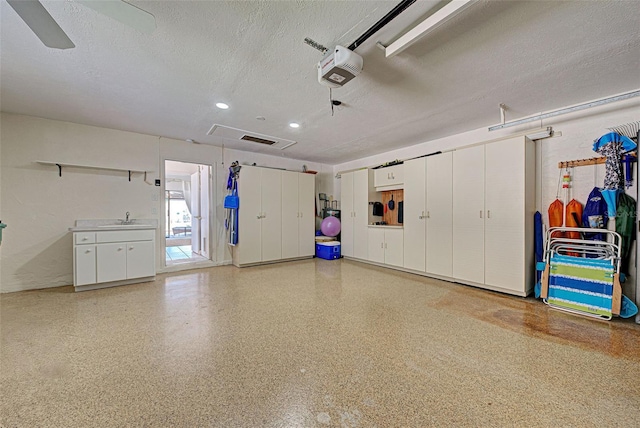 garage with ceiling fan, sink, and a garage door opener