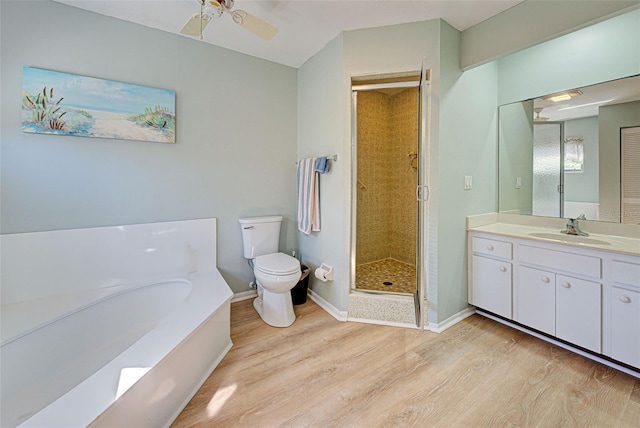 full bathroom with ceiling fan, separate shower and tub, wood-type flooring, toilet, and vanity