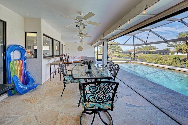 view of patio / terrace featuring a lanai, ceiling fan, and an outdoor bar